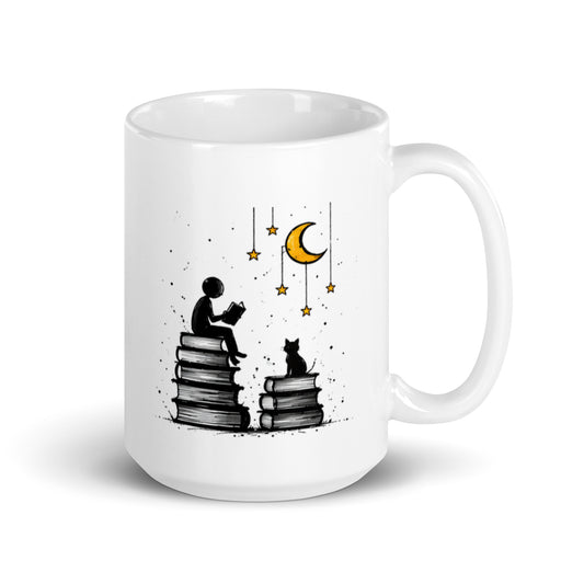 MOONLIT PAGES white 15 oz mug. A reader and a cat sit on stacks of books beneath a crescent moon and stars.